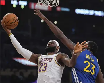  ?? MARK J. TERRILL — THE ASSOCIATED PRESS ?? The Lakers’ LeBron James goes to the basket against Warriors defender Draymond Green during Wednesday’s game.