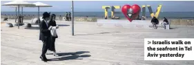  ??  ?? Israelis walk on the seafront in Tel Aviv yesterday