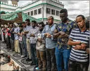  ?? ANDREW RENNEISEN / GETTY IMAGES ?? Men pray Wednesday at a burial ceremony for Abdalla Mohamed Dahir and Feisal Ahmed in Nairobi, Kenya. The two men who worked together were killed after Al-Shabab militants stormed the hotel.