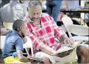  ?? Francine Orr Los Angeles Times ?? CAMERON MORRIS reads with his grandfathe­r Wayne Richardson at the book festival in 2017.