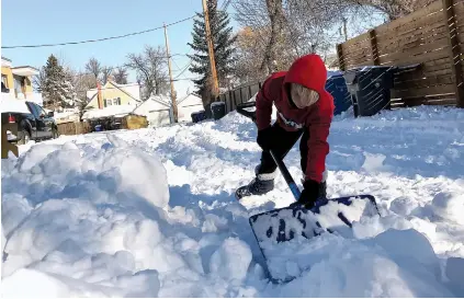  ?? NEWS PHOTO COLLIN GALLANT ?? Orran Illot, 9, pitched in on a day off school to break down the ruts in the alley behind his house on Cambridge Street in Medicine Hat on Monday, the day after a record snowfall swamped the town.