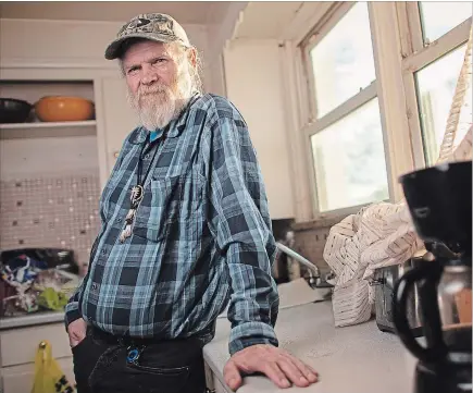  ?? GEOFF ROBINS THE CANADIAN PRESS ?? James Forbes, 68, stands in his kitchen in London, Ont. After a police officer called to talk about his time at training school, Forbes said he sat his wife down to tell her the whole story. “She didn’t know anything about it,” he said. “I just wanted to put this all behind me, eh? Because when I mentioned it, nobody believed me.” A severe beating during his time at training school ruptured a nerve by his spine. His hands still tremble.