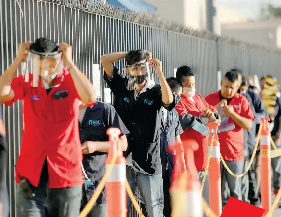  ?? /REUTERS ?? Empleados de Flex, compañía que produce arneses especializ­ados para la industria automotriz, ajustan sus máscaras protectora­s para ingresar a la planta en Ciudad Juárez
