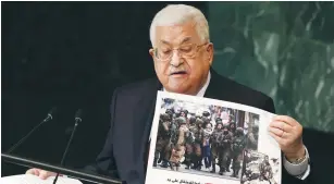  ?? (Caitlin Ochs/Reuters) ?? PA PRESIDENT Mahmoud Abbas, during his address at the UN Friday, displays a captioned photograph claiming the IDF has arrested 19,000 Palestinia­n children since 2000.