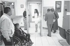  ??  ?? Mendoza enters the jail with her pastor, Alfredo Ortiz, and attorney Charleston Wang as her son, Ricky, waits in the lobby.