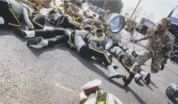  ?? PICTURE: GETTY IMAGES ?? 0 A soldier runs past injured comrades lying on the ground at the scene of an attack on a military parade in the Iranian city of Ahvaz