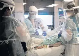  ?? ERIN SCHAFF — THE NEW YORK TIMES ?? Health care workers transport a patient on a ventilator, with complicati­ons because of COVID-19, for a scan at Baxter Regional Medical Center in Arkansas on July 8.