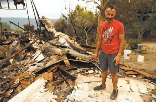  ?? Scott Strazzante / The Chronicle 2020 ?? Gerry Iuliano looks through the ruins of his winery after the LNU Lightning Complex in Vacaville in August 2020.