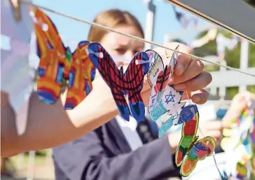  ?? PICTURE: COURTNEY AFRICA ?? DON’T FORGET: Paper butterflie­s were hung by visitors at the Holocaust memorial service held at the Jewish Cemetery, Pinelands, with messages of peace for the lost ones.