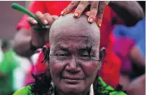  ?? Adnan Abidi / Reuters ?? A supporter of Tamil Nadu leader Jayalalith­aa Jayaram gets her head shaved near the grave in Chennai yesterday.