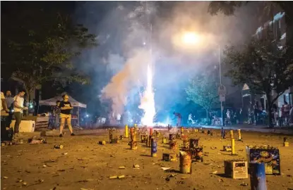  ?? SUN-TIMES FILE PHOTO ?? People watch as a firework goes off at a Fourth of July block party last year in the Pilsen neighborho­od.