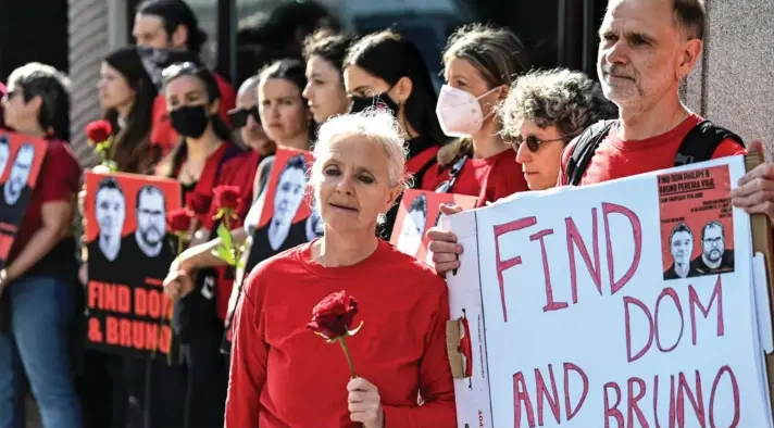  ?? ?? ► Sian y Gareth Phillips, hermanos del periodista británico desapareci­do, sostienen un cartel y una rosa frente a la Embajada de Brasil en Londres.