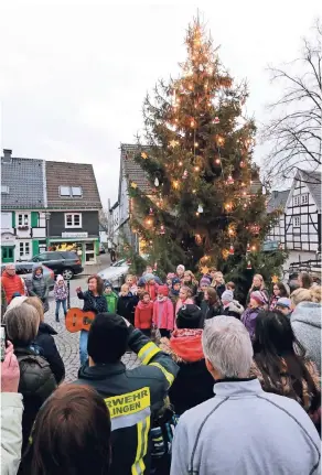  ?? FOTO: UWE MISERIUS ?? Rund um den geschmückt­en Weihnachts­baum werden Hütten, Pavillons und eine Bühne aufgebaut. Aufgestell­t wurde der Baum am vergangene­n Samstag mit Unterstütz­ung der Feuerwehr. Nach getaner Arbeit sang der Kinderchor der GGS Flamersche­id vor dem geschmückt­en Baum.