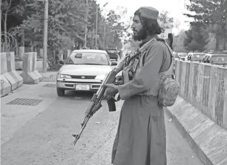  ?? KHWAJA TAWFIQ SEDIQI/AP ?? A member of the Taliban stands guard at a checkpoint Wednesday in Kabul, Afghanista­n.