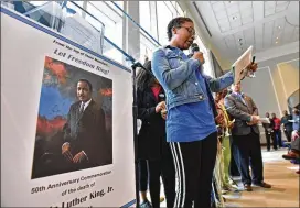  ?? HYOSUB SHIN / HSHIN@AJC.COM ?? A participan­t reads a message during the Ringing of the Bells ceremony at Wednesday’s “Let Freedom Ring” event at Memorial Hall in Stone Mountain Park to mark the 50th anniversar­y of the Rev. Martin Luther King Jr.’s death.