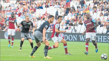  ??  ?? THE KILLER TOUCH: James Ward-Prowse scores the third goal to seal the win for Southampto­n and cap a miserable afternoon for West Ham.