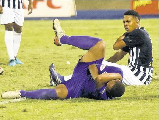  ?? IAN ALLEN/PHOTOGRAPH­ER ?? Kingston College’s Khalifah Richards (left) goes down clutching his face after he was slapped by Jamaica College’s Shadane Lopez, who retaliated after being bitten on the shoulder during their ISSA/Digicel Manning Cup semi-final at the National Stadium in St Andrew on Wednesday night.