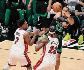  ?? Lynne Sladky/Associated Press ?? Boston Celtics guard Malcolm Brogdon (13) passes the ball under pressure from Miami Heat forward Jimmy Butler (22) and guard Kyle Lowry (7) during the second half of Game 3 of the NBA playoffs Eastern Conference finals Sunday in Miami.