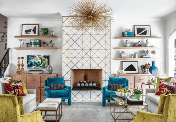  ?? Photos by Kerry Kirk Photograph­y ?? White marble tile with brass inlay creates a feature wall in the living room and is a striking backdrop for the spiky starburst chandelier.