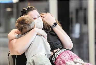  ?? | HENK KRUGER African News Agency (ANA) ?? A MOTHER travelling on flight EK770 arriving from Dubai was seen wearing a protective mask as she embraced her children at Cape Town Internatio­nal Airport yesterday. The coronaviru­s, which emerged in Wuhan, China, in December has infected thousands and triggered alarm around the world.