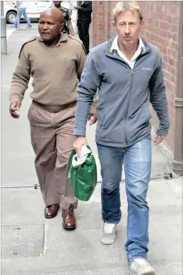  ?? PICTURES: MIKE BEHR ?? Nigel Lee Tucker, 52, the British helicopter pilot facing extraditio­n to the UK on paedophile charges, is escorted by a Correction­al Services official to have a new tracking device fitted.