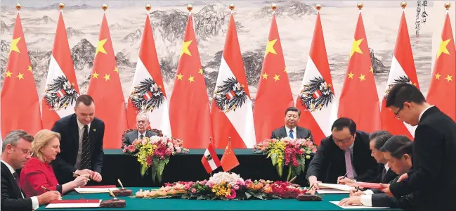  ?? [ Reuters ] ?? Unter den wachsamen Augen der Staatspräs­identen unterschre­iben die Delegation­en aus Österreich und China die vorbereite­ten Verträge.