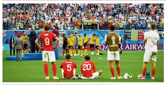  ?? — Reuters ?? Not this time: England players watching their Belgium rivals receiving the bronze medals after their third-place match at the St Petersburg Stadium on Saturday.