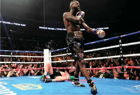  ?? | REUTERS ?? AMERICAN Deontay Wilder reacts after knocking down Tyson Fury during Saturday night’s world heavyweigh­t title fight at the Staples Centre in Los Angeles.