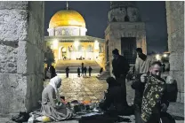  ?? MAHMOUD ILLEAN/THE ASSOCIATED PRESS ?? Palestinia­n Muslims break their Ramadan fast Saturday outside the Dome of the Rock at the Al-Aqsa Mosque in Jerusalem.