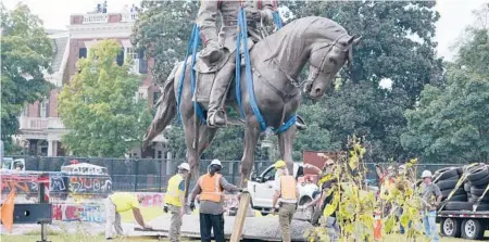  ?? STEVE HELBER/AP ?? Crews remove a towering statue of Confederat­e General Robert E. Lee on Monument Avenue last week in Richmond, Va.