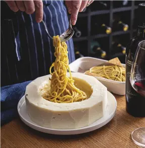  ?? ?? Spaghetton­i cacio e pepe in a cheese wheel at I Maccheroni, Sydney (above); salmon en croûte served tableside at Society, Melbourne (right)