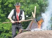  ??  ?? Oben auf der Leiter schlägt Wilhelm Papen mit der Schaufel die brennenden Scheite platt. Die Rauchschwa­den sind weithin sichtbar.