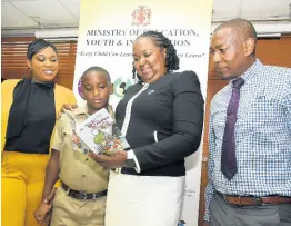  ?? CONTRIBUTE­D ?? Acting permanent secretary in the Ministry of Education, Youth and Informatio­n, Dr Grace McLean (third left), peruses the book ‘The Adventures of Goober: The Alien from Mars’, written by 10-year-old Kanton Hardy (second left) when he was eight years old. Occasion was a recent visit to the education ministry in Kingston. Sharing the moment (from left) are Kanton’s mother, Tavia Bell-Hardy (left), and his father, O’Neill Hardy.