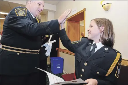  ?? CLIFFORD SKARSTEDT EXAMINER ?? City police Chief Murray Rodd high fives Chief for a Day Lauren Graham, a Grade 6 student at Monsignor O'Donoghue School, on Wednesday night.