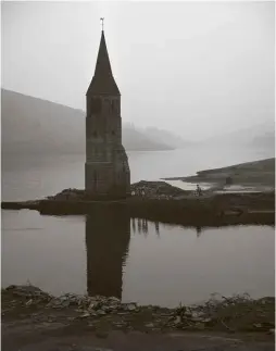  ??  ?? LEFT: The spire of Derwent Church high and dry in the drought of 1947. BELOW LEFT: On a 1946 postcard, the spire is visible above the reservoir’s waters, which had risen due to heavy rain and floods.