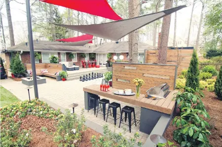  ??  ?? Above: Atlanta-based designer Chip Wade incorporat­ed a multi-use recreation space with a central-court-style hardscape in this backyard. The paver area doubles as entertaini­ng and game space. Below left: A convertibl­e pavilion with a golf simulator...