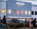  ?? ?? People arrive for work at the Amazon distributi­on center in the Staten Island borough of New York, on Oct 25, 2021. (AP)