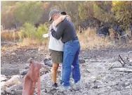  ?? CHARLIE RIEDEL/ASSOCIATED PRESS ?? Justo and Bernadette Laos hug while looking through the charred remains of the home they rented that was destroyed by the Kincade Fire last week in California.