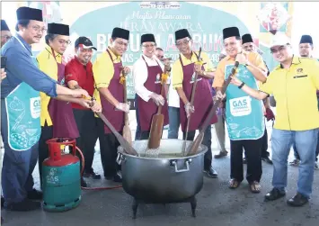  ??  ?? Abang Johari, flanked by Abdul Karim (third right) and Dr Abdul Rahman (fourth left), leads the stirring of ‘bubur lambuk’ at the event. At second right is Safiee. — Photo by Muhammad Rais Sanusi