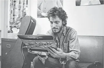  ?? Art Maillet ?? Bruce Springstee­n gets his first look at a finished copy of his debut record, “Greetings from Asbury Park, N.J.,” in 1973. Springstee­n candidly writes about his successes and troubles in his memoir, “Born to Run.”