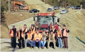  ?? PHOTO: STEPHEN JAQUIERY. ?? We made it . . . Some of the community members who worked for five months to rebuild a section of Haven St for vehicle access. Standing (from left) are project manager Bruce Wheeler, Bill Pile, Ben Gold, Henry Matheson, James Matheson, Lance Hyland and Tony Hore with (sitting, from left) Robbie Mitchell, Laurence McGuire, Sue Tisdall with Lucy, and Craig Mitchell.