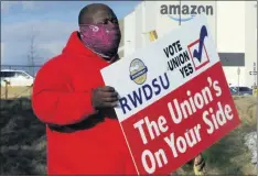  ?? THE ASSOCIATED PRESS ?? Michael Foster of the Retail, Wholesale and Department Store Union holds a sign outside an Amazon facility in February when labor was trying to organize workers in Bessemer, Ala.