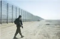  ?? (Marc Israel Sellem/The Jerusalem Post) ?? A SOLDIER WALKS next to the fence on the Jordanian border near Eilat last year.