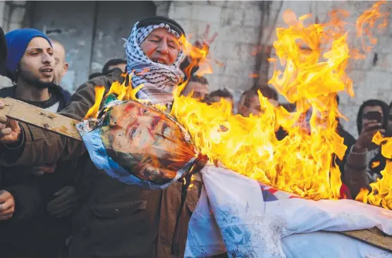  ?? FIRED UP: Irate Palestinia­n protesters burn an effigy of US President Donald Trump in the West Bank city of Nablus. Picture: AFP ??