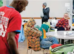  ??  ?? A man wears his coat while he naps at one of the tables in the dining space at the Homeless Alliance day shelter on NW 3 Street on Oct. 19.