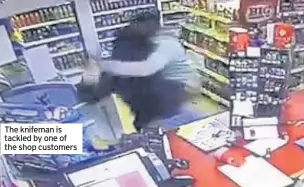  ??  ?? The knifeman is tackled by one of the shop customers