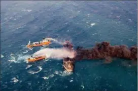  ?? MINISTRY OF TRANSPORT VIA AP, FILE ?? In this file photo provided by China’s Ministry of Transport, firefighti­ng boats work to put out a blaze on the oil tanker Sanchi in the East China Sea off the eastern coast of China. The U.S.’s self-described “largest-ever” sanctions list targeting Iran includes the oil tanker that already sunk and a bank long since closed. Iranian Foreign Minister Mohammad Javad Zarif in a tweet late Monday called the re-imposition of sanctions a desperate move and said they target ordinary Iranians.