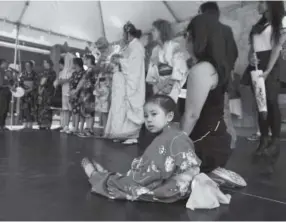  ??  ?? Ellie Lo, 4, sits on the stage with her aunt, Courtney Ozaki Moch, after the Japanese Style Parade at the Denver Cherry Blossom Festival. Andy Cross, The Denver Post