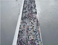  ?? EFE ?? Miles de hondureños esperan en el puente entre Guatemala y México.
