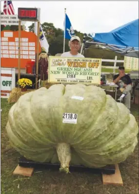  ?? AP PHOTO BY SUSAN JUTRAS ?? In this Oct. 7 photo provided by Susan Jutras, Joe Jutras stands with his world record breaking, 2,118-pound squash, following a weigh-in at Frerichs Farm in Warren, R.I. Jutras has become the first grower in the world to achieve a trifecta in the...